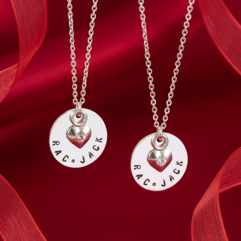 Two personalized sterling silver necklaces with heart-shaped charms and customized engravings.